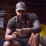 A UPS deliveryman with tattoos checks his smartphone while on a delivery in New York City.